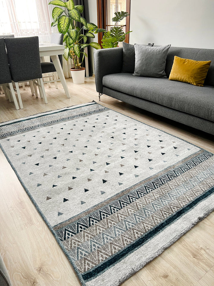 Tapis triangulaire bleu, doré, gris et blanc cassé